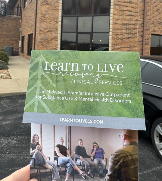 holding flyer by building.jpg